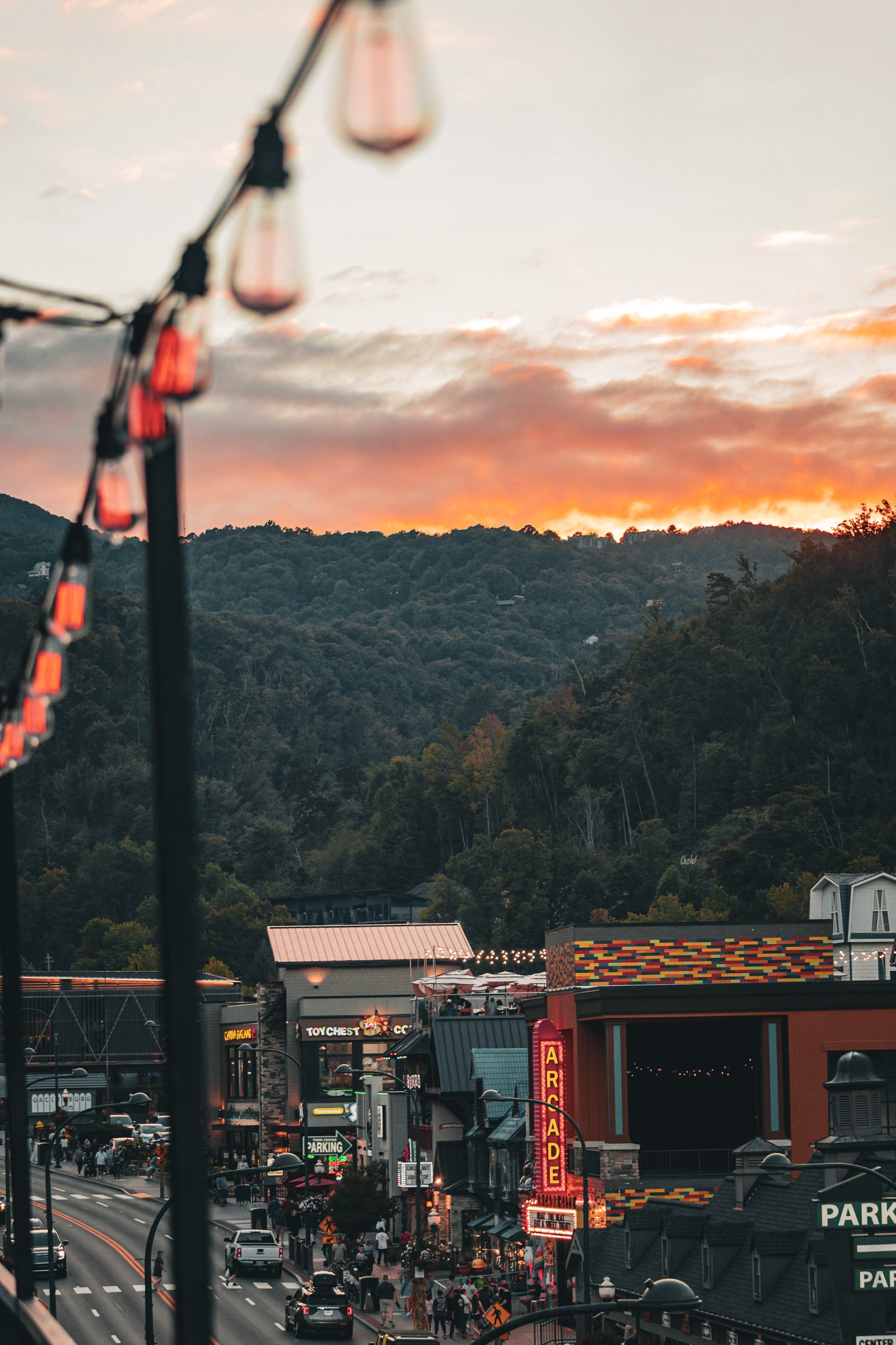 Autumn sunset over the Great Smoky Mountains and neon arcade signs on the downtown Gatlinburg Parkway